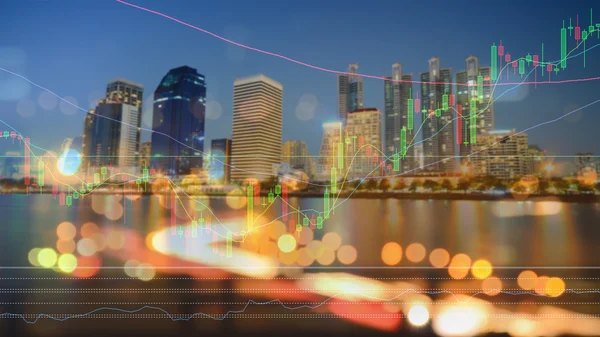 Бизнес-график на экране на фоне современного ночного города — стоковое фото
