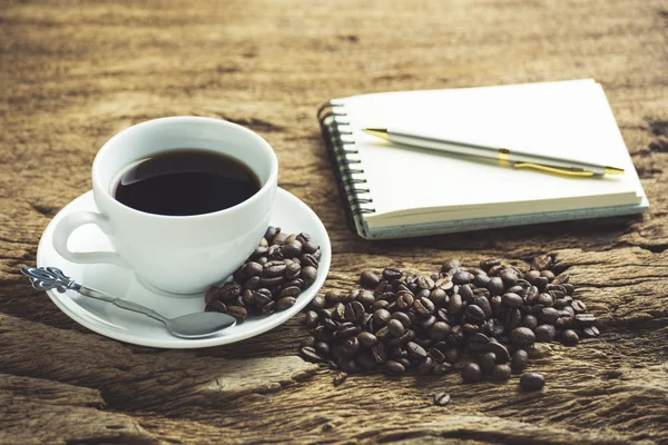 Vit kaffekopp och rostade kaffebönor runt — Stockfoto
