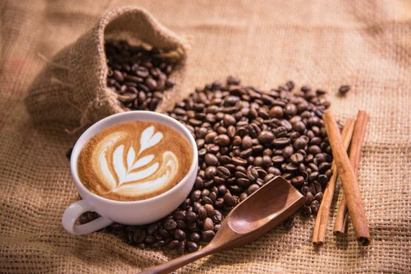 Taza de café blanco y granos de café tostados alrededor — Foto de Stock