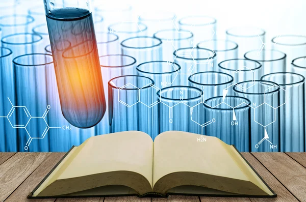 blank open book with science laboratory test tubes background