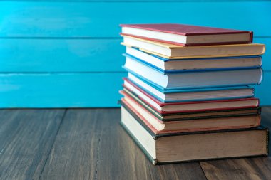 Mavi ahşap duvar arka plan ile kitap yığını
