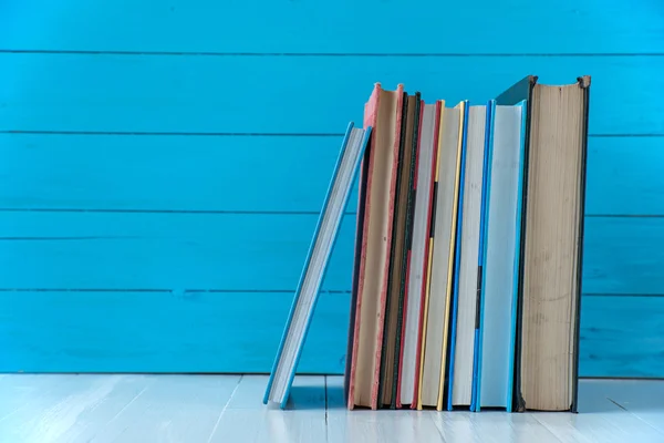 Pilha de livro com fundo de parede de madeira azul — Fotografia de Stock