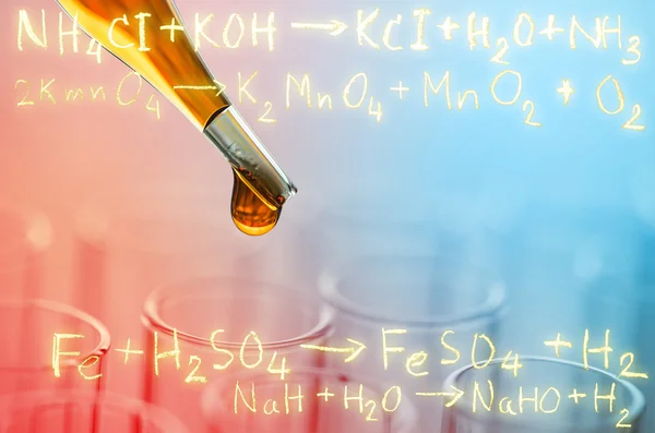 Laboratory test tubes with gold chemical equation background — Stock Photo, Image