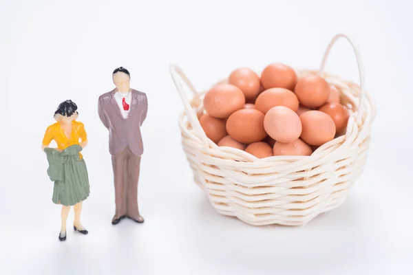 Miniature couple with egg basket on white background — Stock Photo, Image