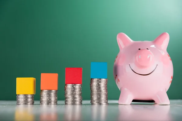 Groeiende munt stack en roze spaarvarken — Stockfoto