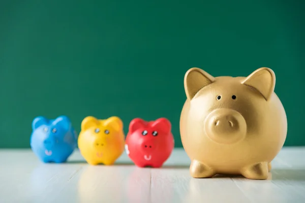 Color piggy bank on green background — Stock Photo, Image