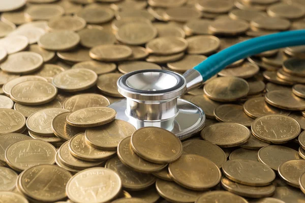 Stethoscope on gold coins background — Stock Photo, Image