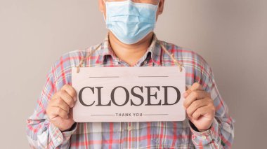 Kapalı tabela taşıyan adam boynunda asılı.