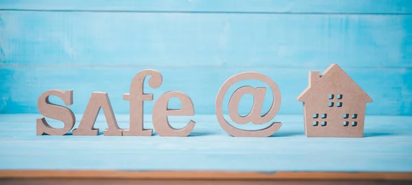 wood text safe at home on light blue wood background