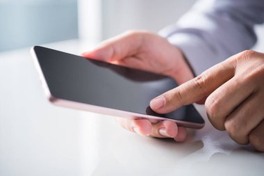 Akıllı telefon kullanan işadamı, akıllı telefon ekranını işaret ediyor.