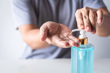Coronavirüs bulaşmasın diye elini alkol jeliyle yıkayan adam.