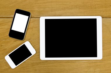 Mobil tablet üzerinde ahşap masa arka plan, üstten görünüm