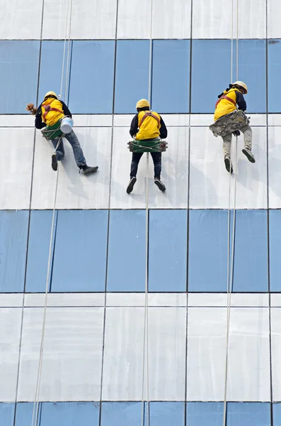 Group of workers cleaning windows on high rise building — Stock Photo, Image