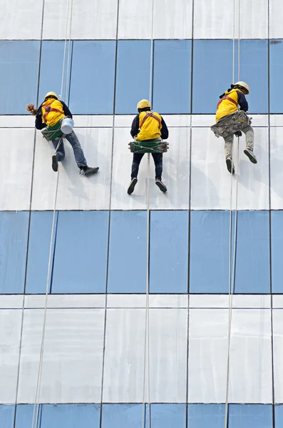 group of workers cleaning windows on high rise building