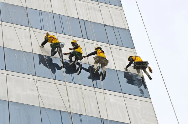 Grupo de trabajadores limpiando ventanas en un edificio de gran altura —  Fotos de Stock