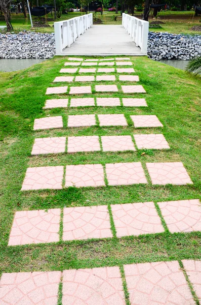 Colorful cement walkway on green grass — Stock Photo, Image