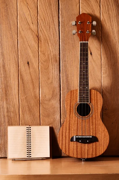 Гитара на укулеле с ноутбуком — стоковое фото