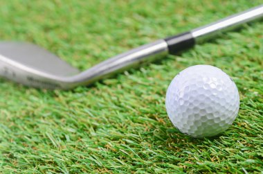 Demir ve golf topu yeşil çim sahada