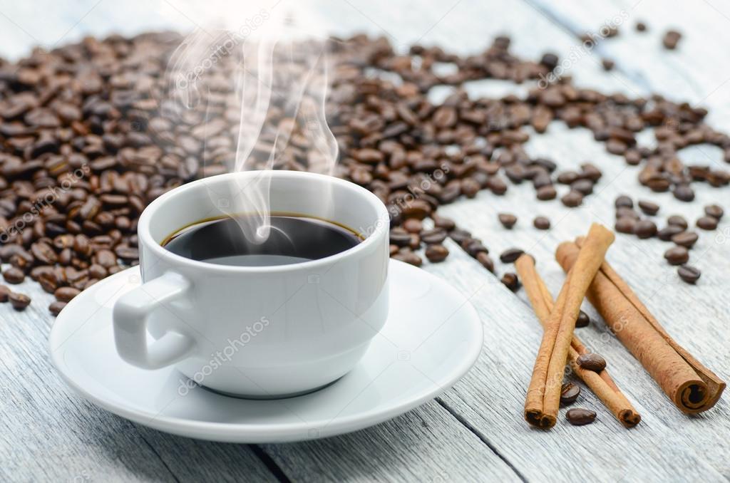 Coffee cup with smoke and coffee beans around