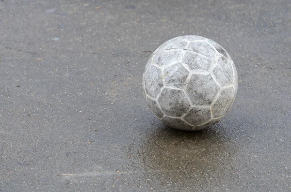 Old soccer ball on cement floor — Stock Photo, Image