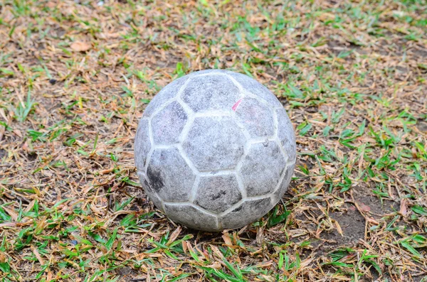 Old soccer ball on grass field — Stock Photo, Image