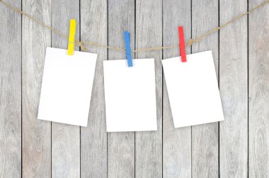 Clothespins ile woode üzerinde asılı üç boş beyaz fotoğraf çerçeveleri