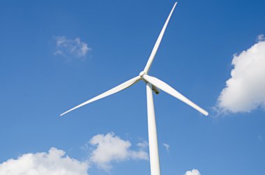 Bulutlu mavi gökyüzü arkaplanına karşı rüzgar türbini