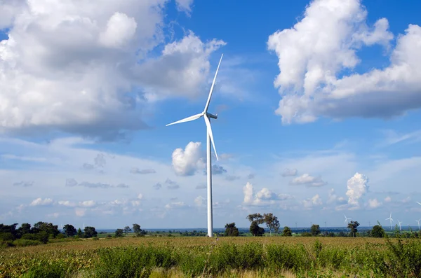 Turbina wiatrowa na tle zachmurzonego błękitnego nieba — Zdjęcie stockowe