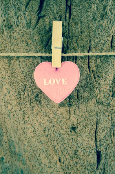 Lovely pink hearts hanging on the clothesline on old wood backgr — Stock Photo, Image