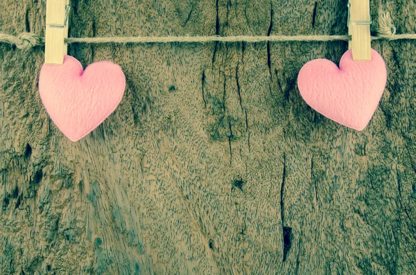 Lovely pink hearts hanging on the clothesline on old wood backgr — Stock Photo, Image