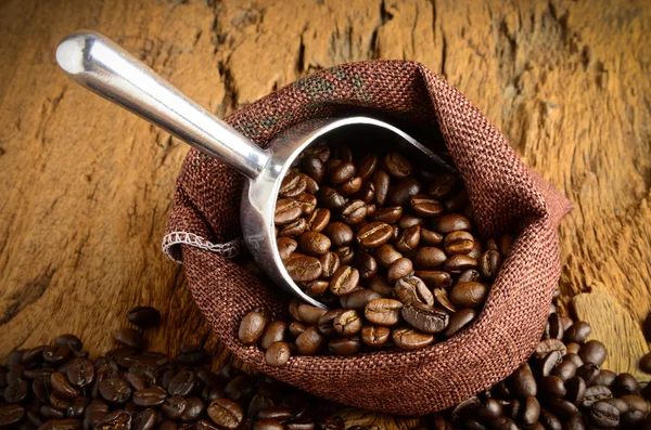 Pražená zrnková káva v sáčku a kávová zrna a okolí — Stock fotografie