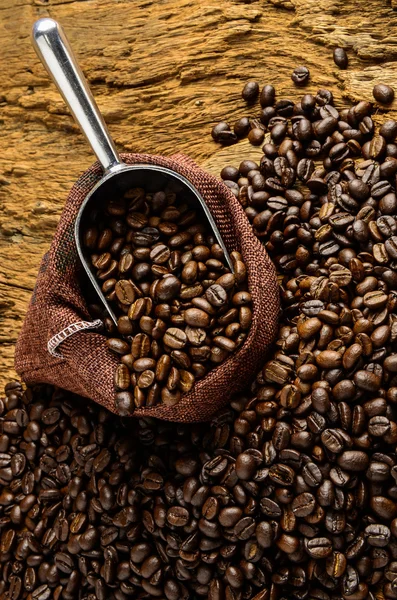 Gebrande koffiebonen in zak en koffiebonen rond — Stockfoto