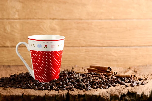 Taza de café en la mesa de madera y granos de café tostados alrededor — Foto de Stock