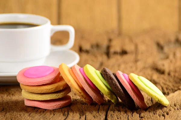 Šálek kávy a efektní cookie na dřevěný stůl — Stock fotografie