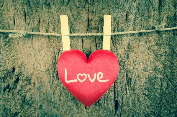 Lovely red hearts hanging on the clothesline on old wood backgro Stock Photo