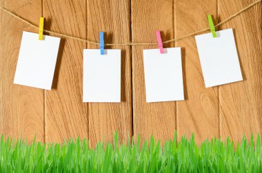 Clothespins ile ahşap arka plan asılı boş beyaz fotoğraf çerçeveleri