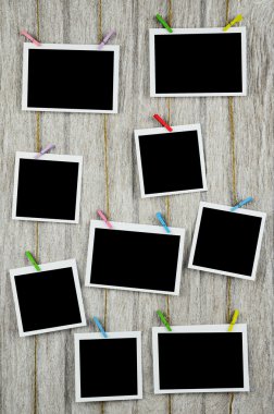clothespins ile ahşap arkasında asılı boş siyah fotoğraf çerçeveleri