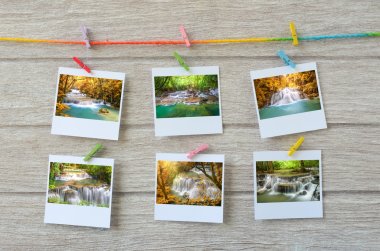 waterfall photos hanging with clothespins on wooden background