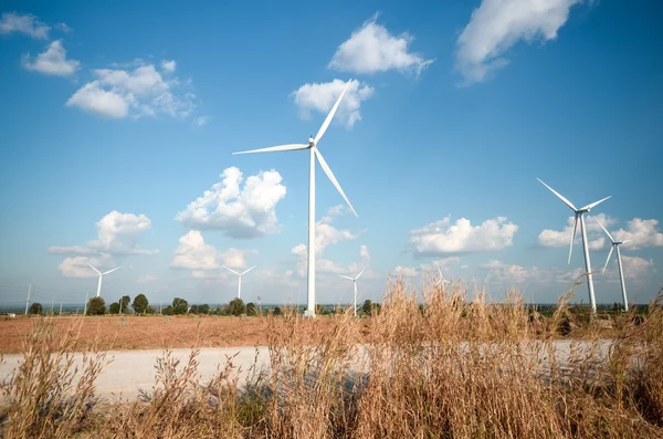 Turbina wiatrowa na tle zachmurzonego błękitnego nieba — Zdjęcie stockowe