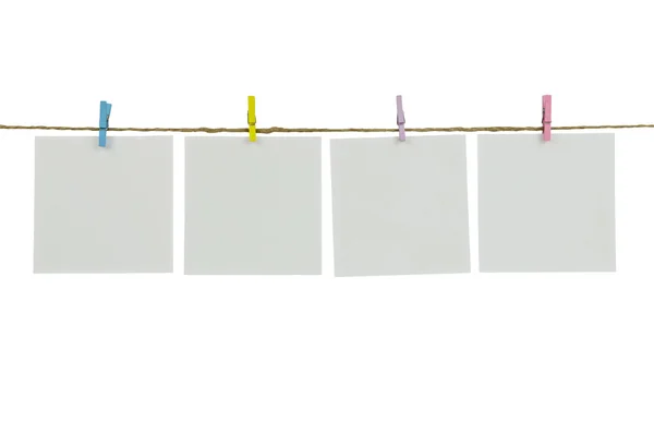 Leere weiße Fotorahmen, die mit Wäscheklammern auf Holzgrund hängen — Stockfoto