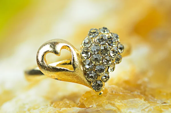 Золотое кольцо в форме сердца на мраморном фоне — стоковое фото