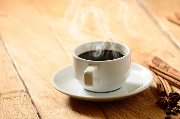 Copo de café branco com fumaça e grãos de café ao redor — Fotografia de Stock