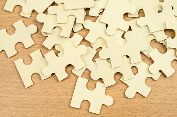 Jigsaw puzzle pieces on wood background — Stock Photo, Image
