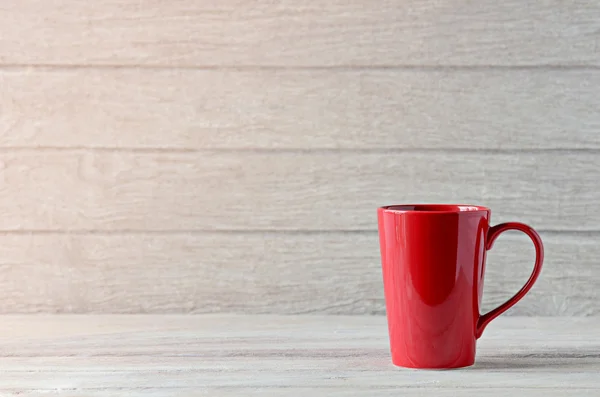 Röd kaffekopp på träbord — Stockfoto