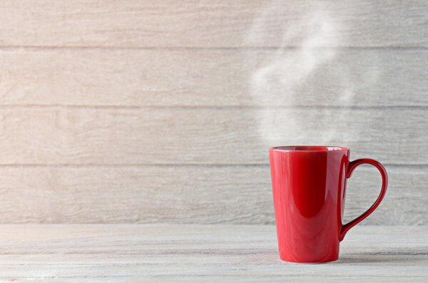 Red coffee cup on wooden table
