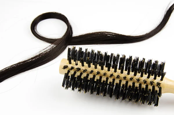 Escova de cabelo com cabelos longos no fundo branco — Fotografia de Stock