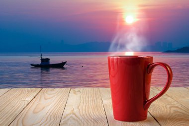 Dumanlı sun rise arka plan üzerinde kırmızı kahve fincanı