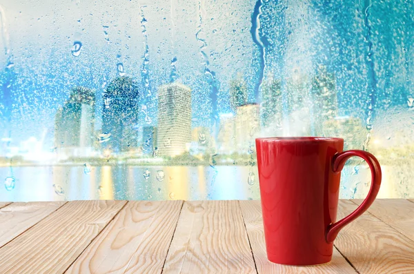 Rote Kaffeetasse mit natürlichen Wassertropfen auf Glasfensterhintergrund — Stockfoto