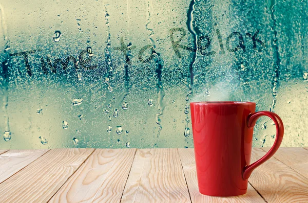 Red coffee cup with smoke on water drops glass window background — Stock Photo, Image
