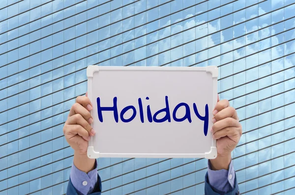Hombre de negocios mano sosteniendo pizarra blanca con texto "Vacaciones " — Foto de Stock